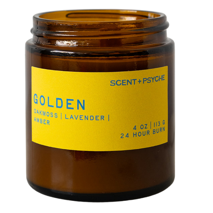 An amber glass jar candle with a bright yellow label reading 'GOLDEN' and 'Scent + Psyche' on a plain white background.