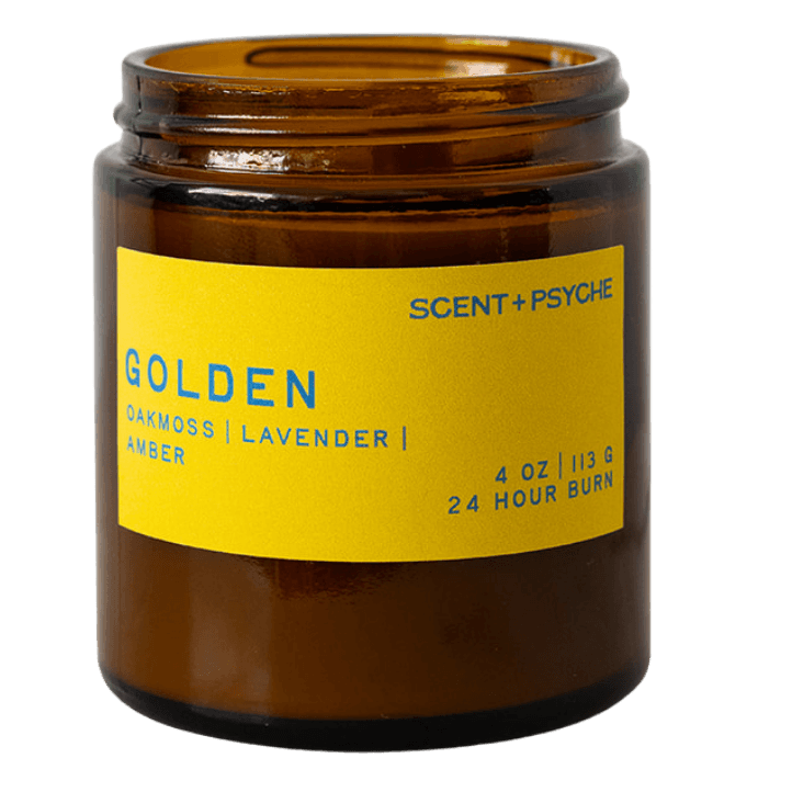 An amber glass jar candle with a bright yellow label reading 'GOLDEN' and 'Scent + Psyche' on a plain white background.