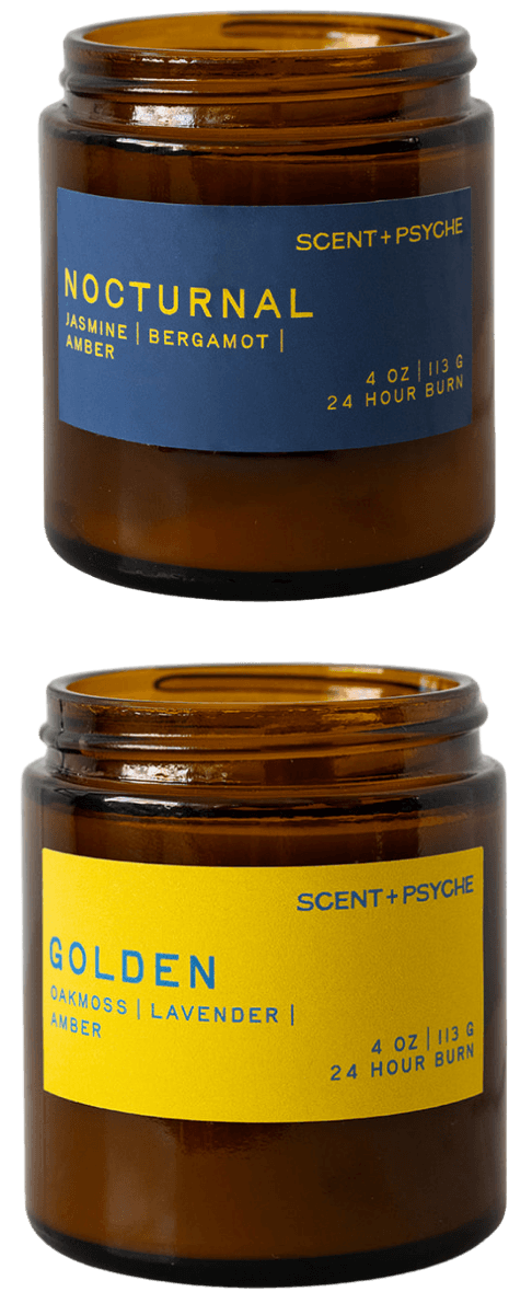 Two amber glass jar candles from Scent + Psyche on a white background, one labeled 'Nocturnal Jasmine & Bergamot' with a blue label and the other labeled 'Golden Lavender' with a yellow label.