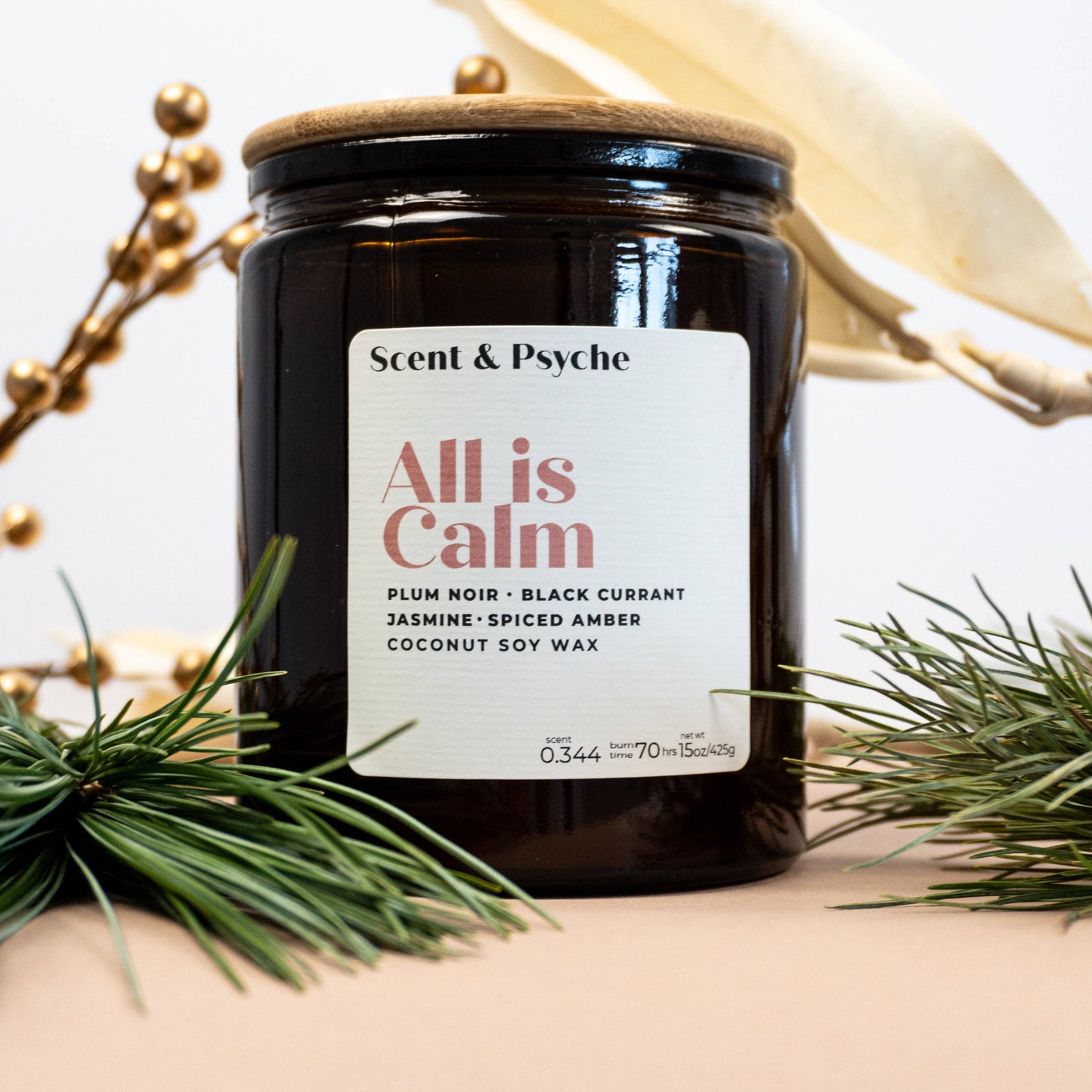 All is Calm Scented Candle - 15oz in amber jar with festive holiday decor, featuring notes of plum noir, black currant, and spiced amber.