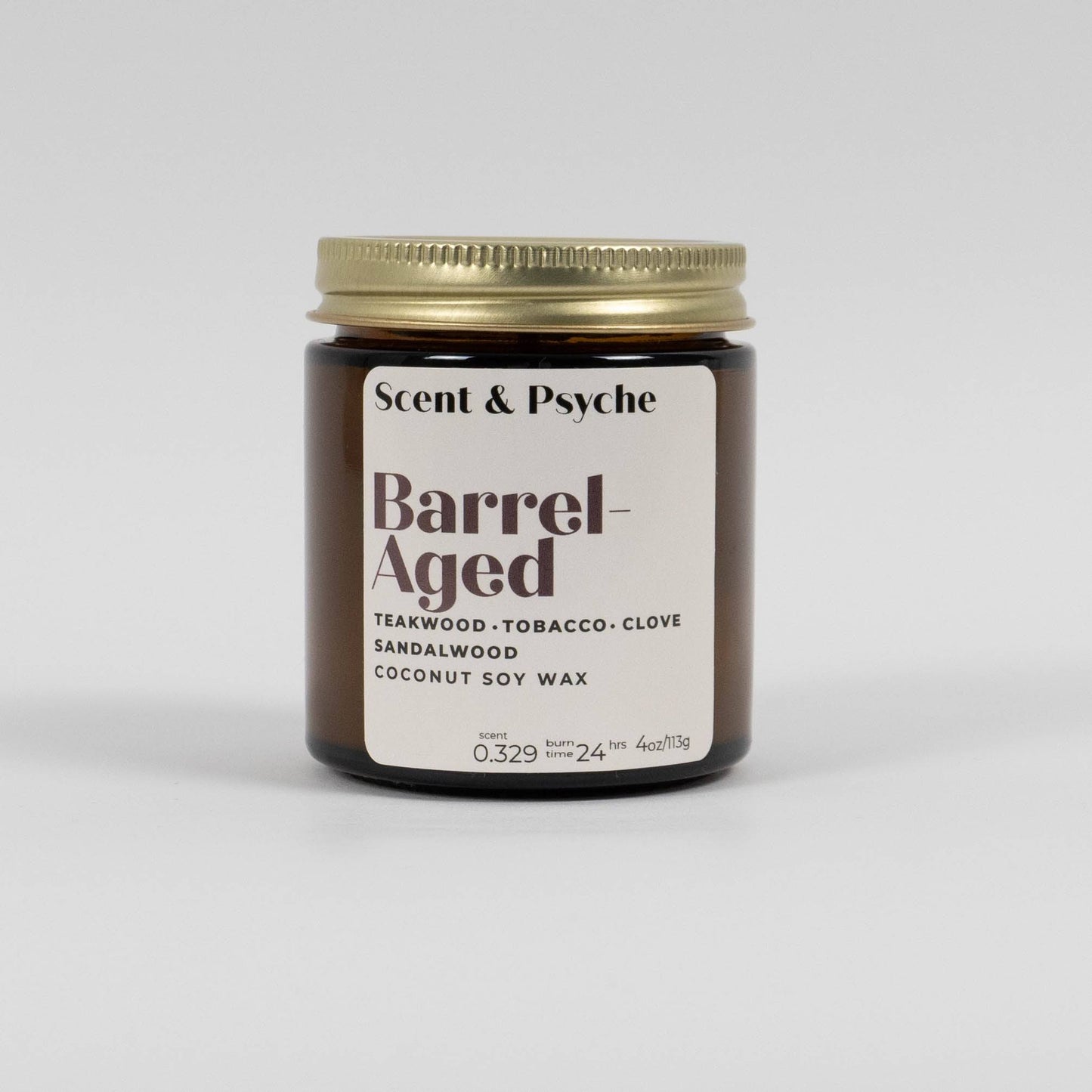 Barrel Aged Scented Candle in a 4oz amber jar with a gold lid. Features teakwood, tobacco, clove, and sandalwood fragrance in coconut soy wax.