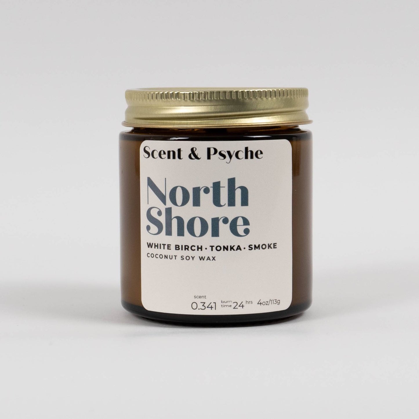 Northshore Scented Candle in a 4oz amber jar with a gold lid. Features a coconut soy wax blend with white birch, tonka, and smoke fragrance.