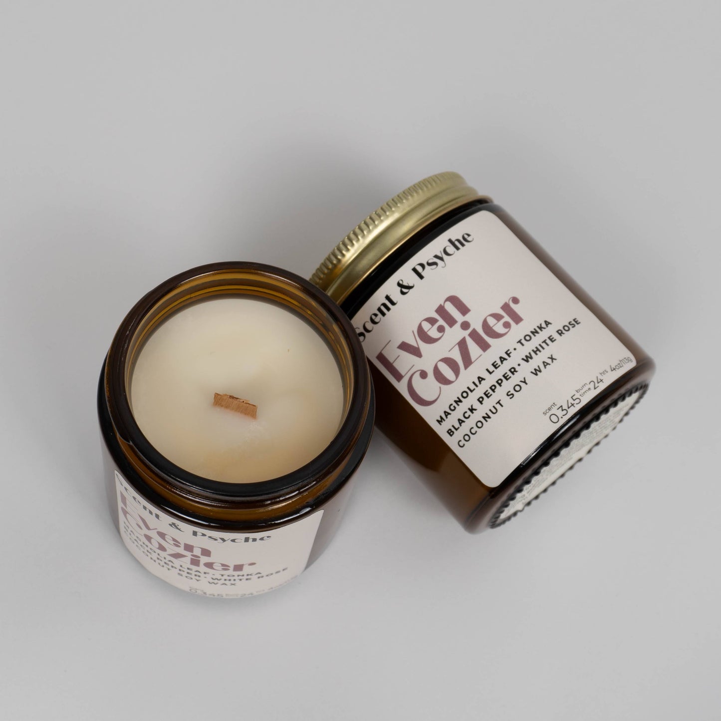 Open 4oz Even Cozier Scented Candle with wood wick and amber jar, clean-burning coconut soy wax ideal for cozy home ambiance.