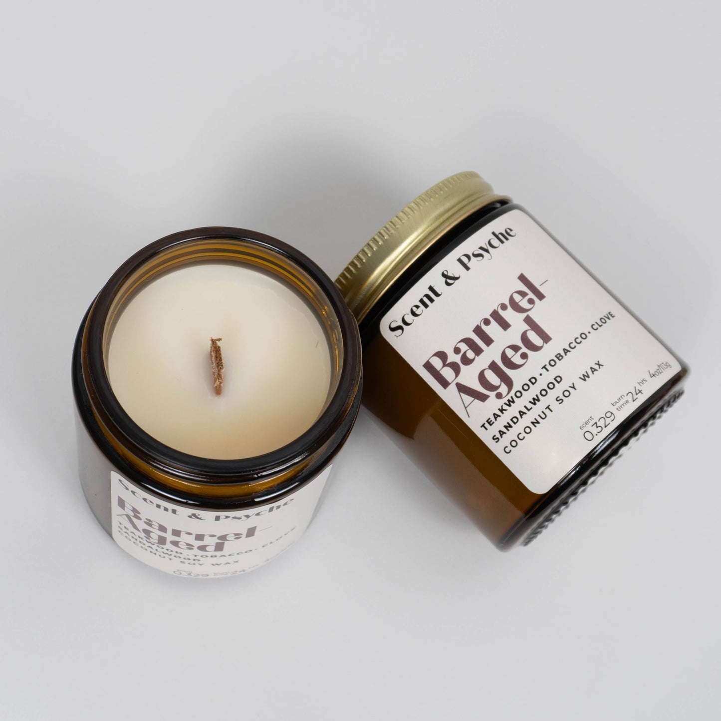 Open and closed Barrel Aged Scented Candles in 4oz amber jars. Rich woodsy fragrance with teakwood, tobacco, and sandalwood in coconut soy wax.