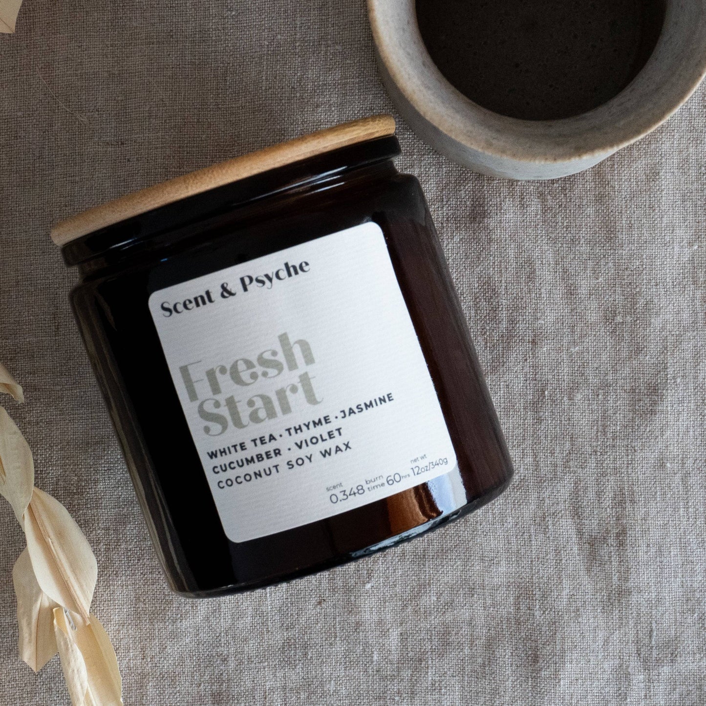 Fresh Start Wood Wick Scented Candle in a 12oz amber jar with a wooden lid. Features a coconut soy wax blend infused with white tea, thyme, and jasmine.