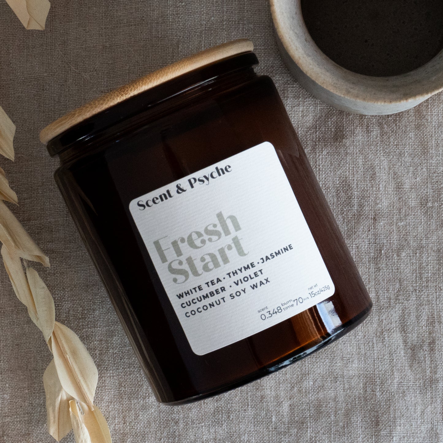 Fresh Start Wood Wick Scented Candle in a 15oz amber jar with a wooden lid. Features a coconut soy wax blend with white tea, thyme, and jasmine fragrance.