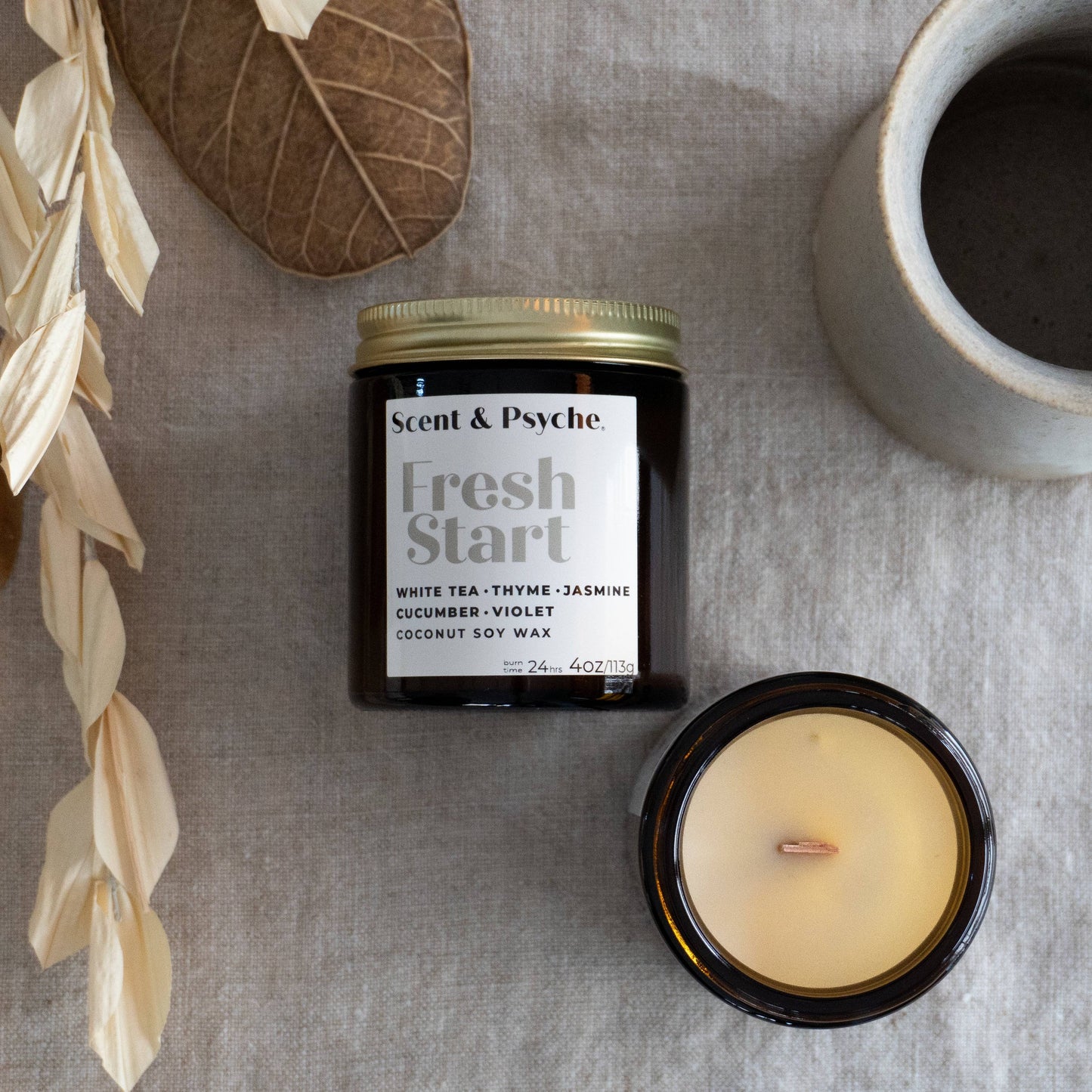 Fresh Start Wood Wick Scented Candle in a 4oz mini amber jar. Features a coconut soy wax blend with white tea, thyme, jasmine, cucumber, and violet fragrance.