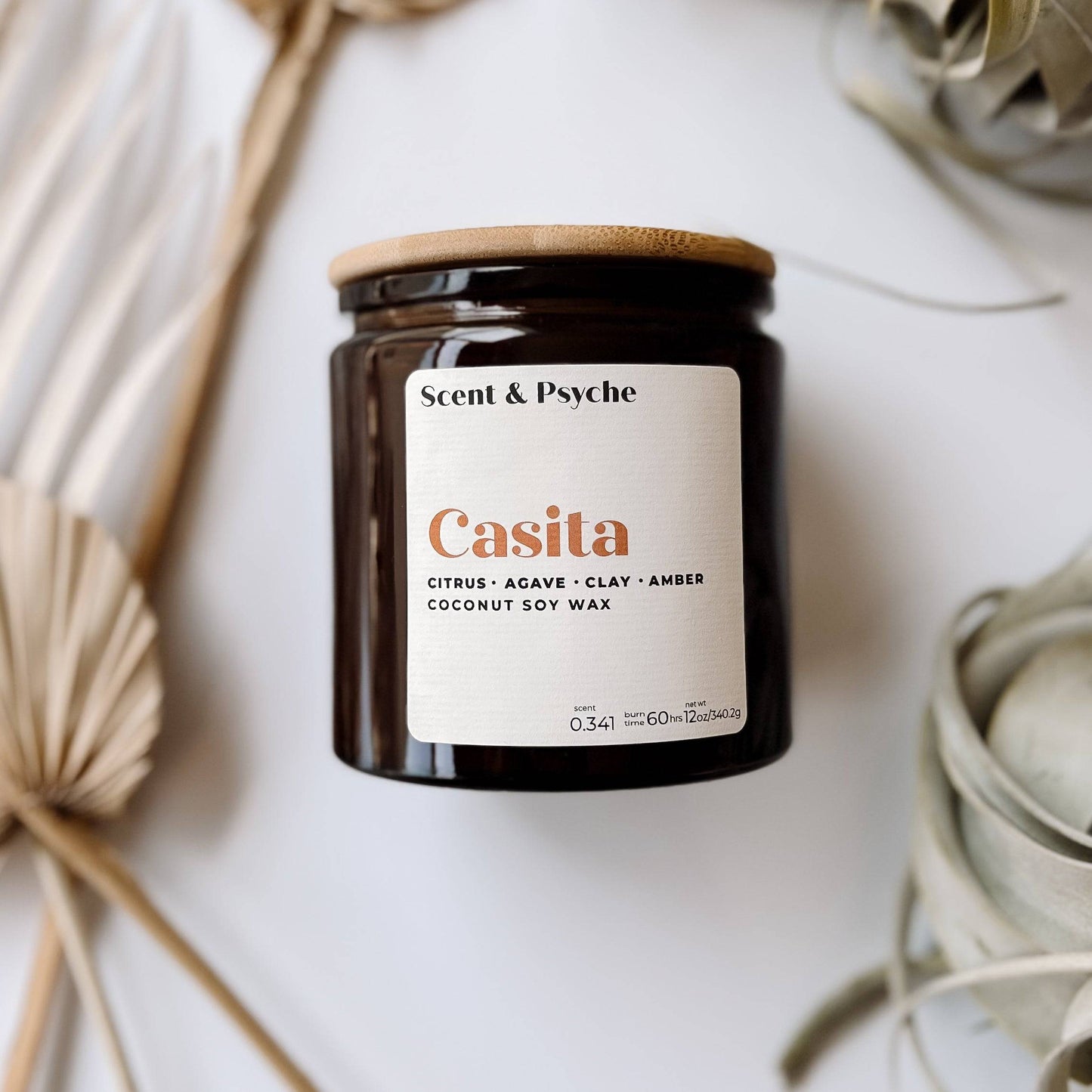 Casita Scented Candle in a 12oz amber jar with a wooden lid. Features notes of citrus, agave, clay, and amber, made from coconut soy wax.