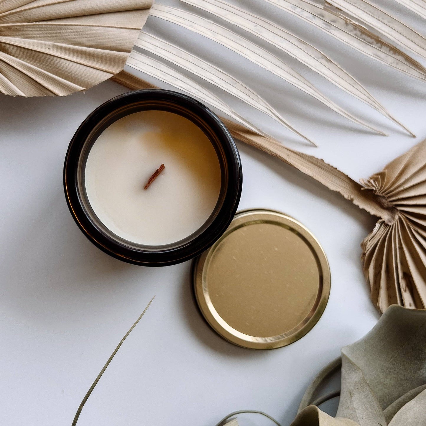 Open Casita Scented Candle in a 4oz amber jar, revealing a wooden wick and smooth coconut soy wax. Comes with a gold metal lid for a stylish touch.