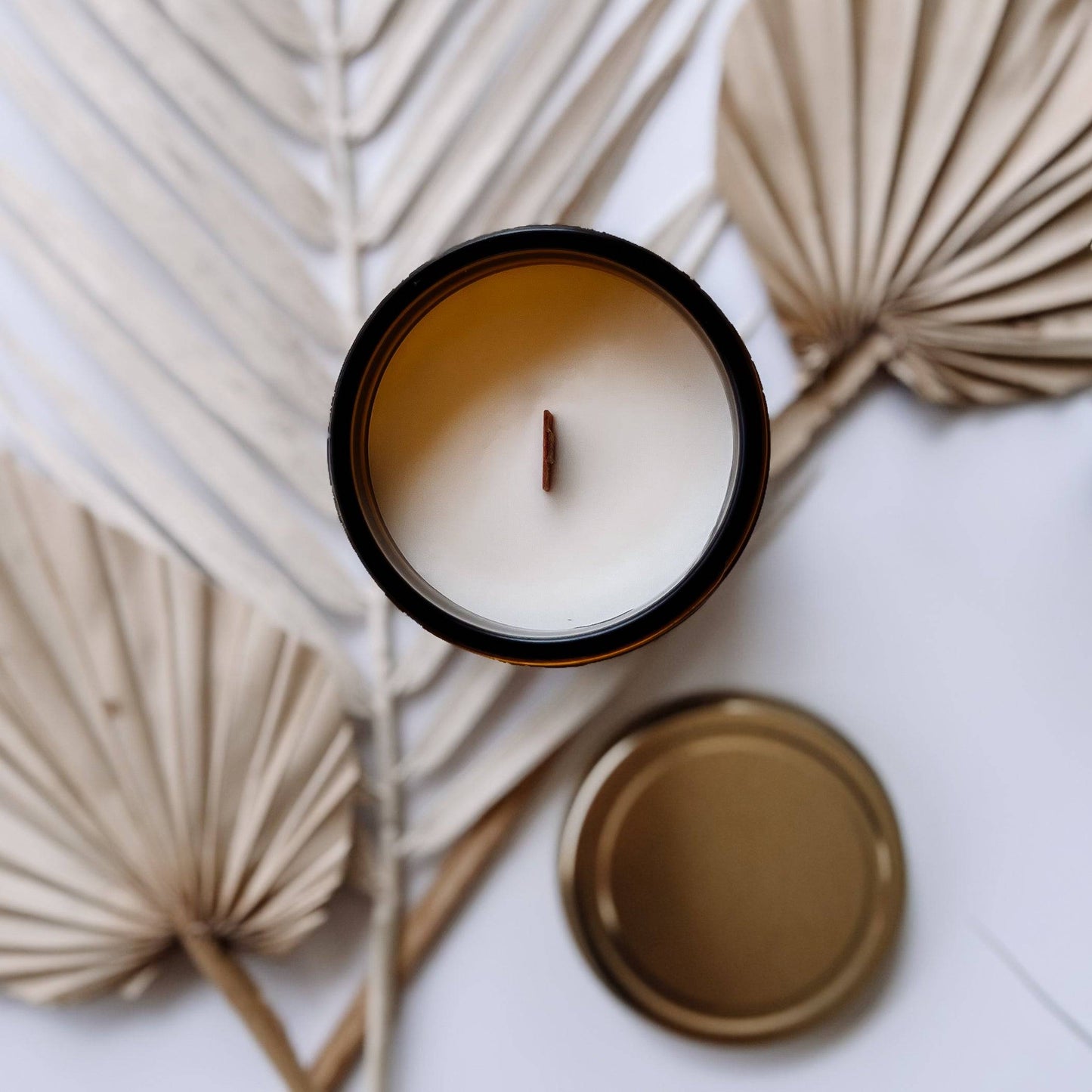 Top view of the Orchid Santal Scented Candle in a 7oz amber jar, showcasing a smooth coconut soy wax surface with a wooden wick. Ideal for a cozy ambiance.