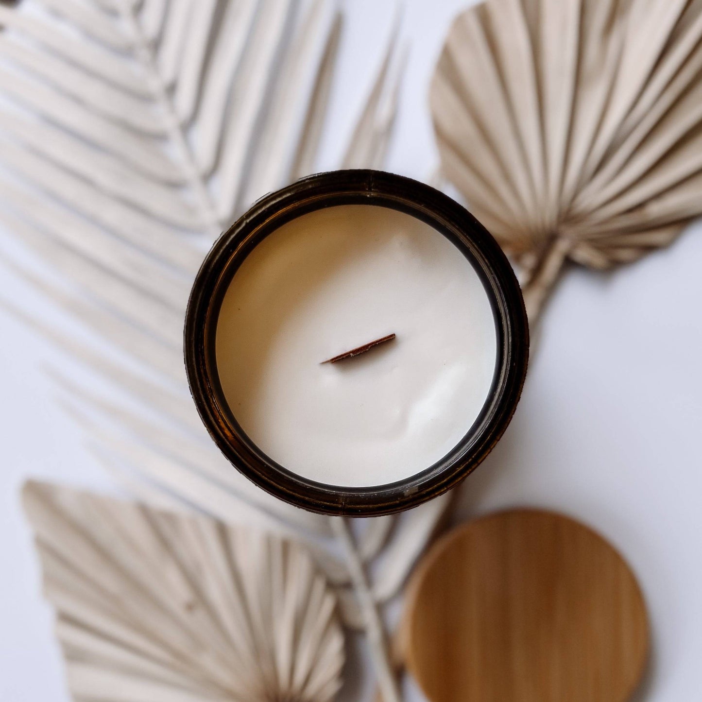 Top view of Orchid Santal Scented Candle - 15oz, showcasing smooth coconut soy wax and a wooden wick. Elegant home fragrance in an amber jar.