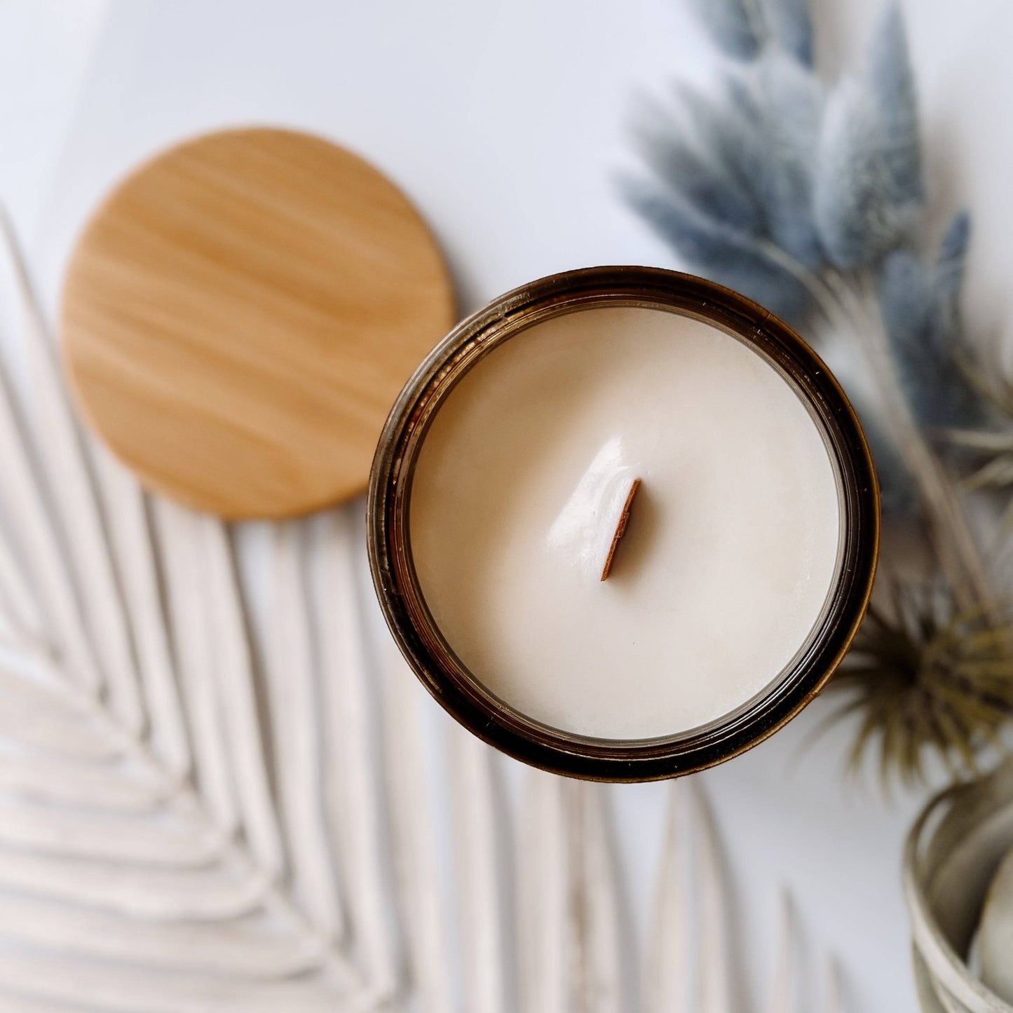 Top view of Adrift Scented Candle in a 12oz amber jar, showcasing a wooden wick and creamy coconut soy wax. Elegant home fragrance option.