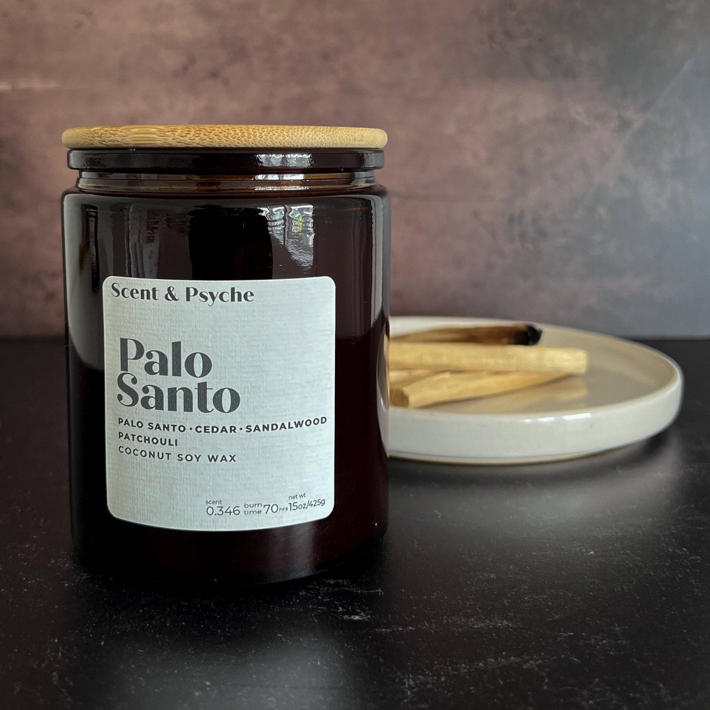 Palo Santo Scented Candle - 15oz in an amber glass jar with a wooden lid, featuring a coconut soy wax blend. Earthy fragrance with cedar, sandalwood, and patchouli notes.