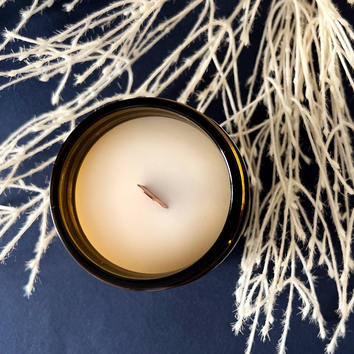 Top view of Nocturnal Scented Candle in a 7oz amber jar, showcasing a smooth coconut soy wax surface with a wooden wick. Elegant home fragrance for a cozy ambiance.
