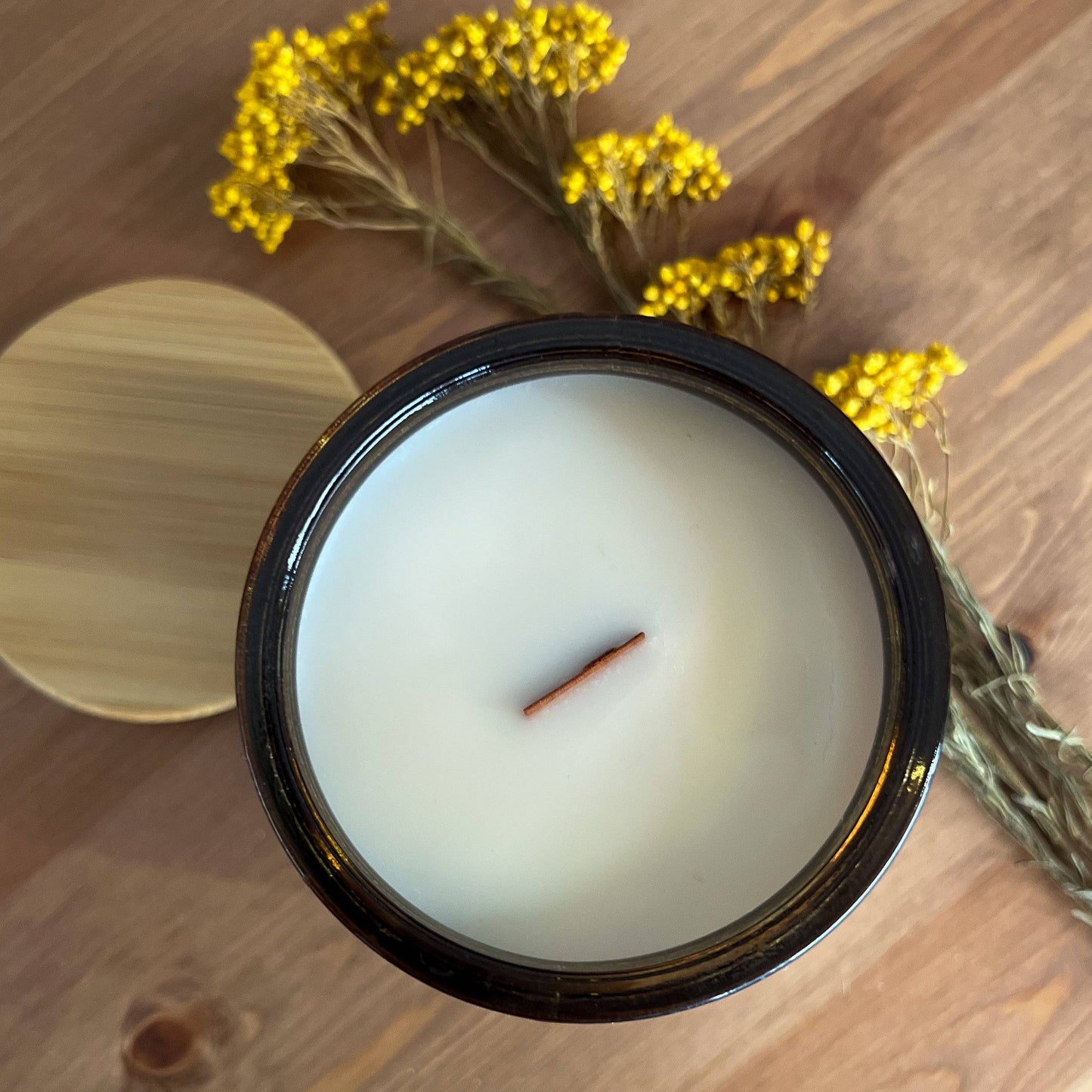 Top view of the Amber Moon Scented Candle in a 15oz amber jar, showcasing a wooden wick and smooth coconut soy wax. Ideal for cozy home ambiance.