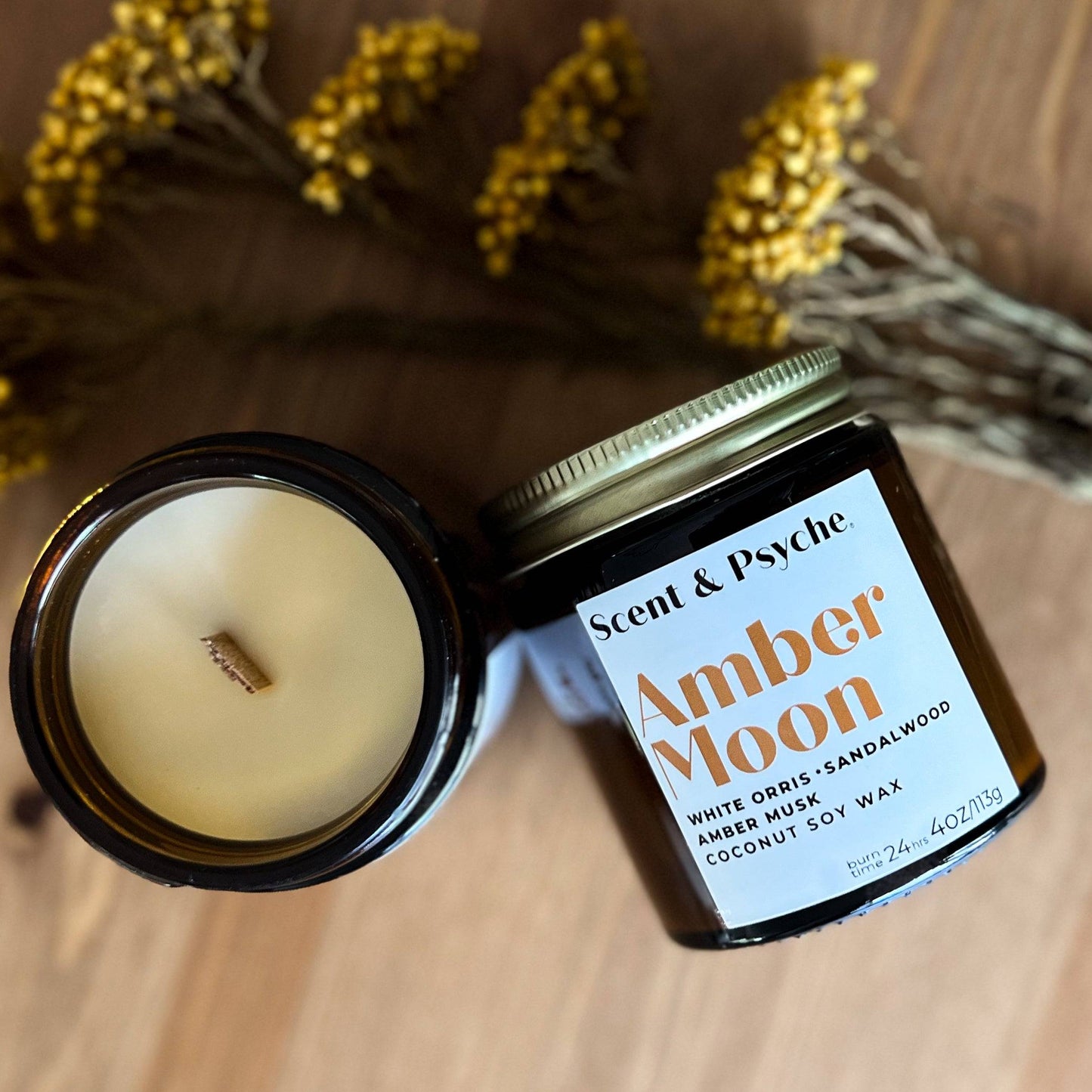 Amber Moon Scented Candle in a 4oz amber jar with a wooden wick, featuring notes of white orris, sandalwood, and amber musk. Perfect for a cozy fall ambiance.