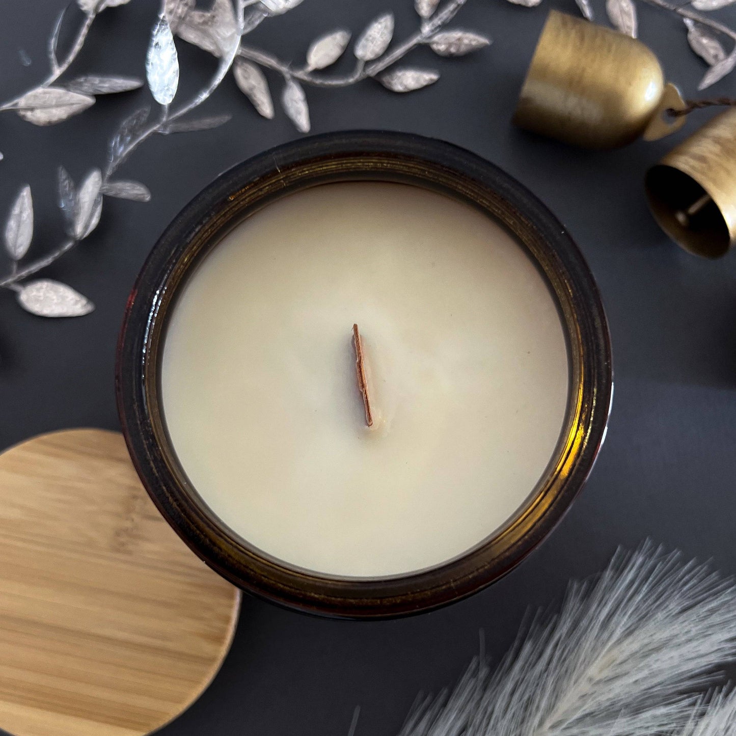 Top view of Noel Wood Wick Scented Candle in a 15 oz amber jar. Smooth coconut soy wax with a centered wooden wick for a clean, even burn.