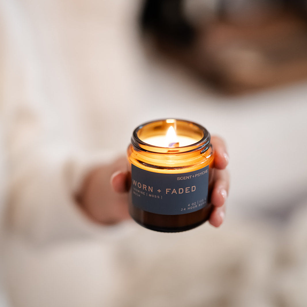 Worn and Faded amber jar candle in moody setting, grounding jasmine moss musk candle — Scent & Psyche