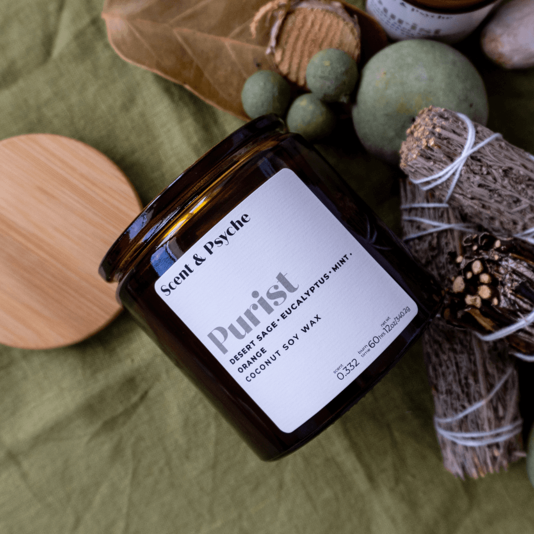 Purist Scented Candle in a 12oz amber jar with a minimalist label, featuring notes of desert sage, eucalyptus, and mint. Made from coconut soy wax.