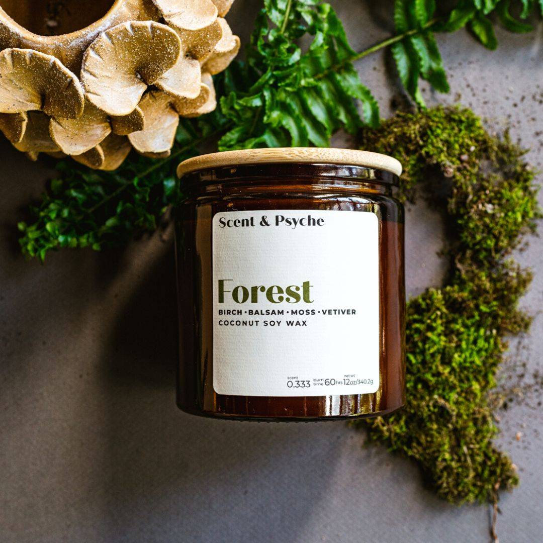 Forest Scented Candle in a 12oz amber jar with a wooden lid, featuring birch, balsam, moss, and vetiver fragrance. Perfect for home ambiance and relaxation.