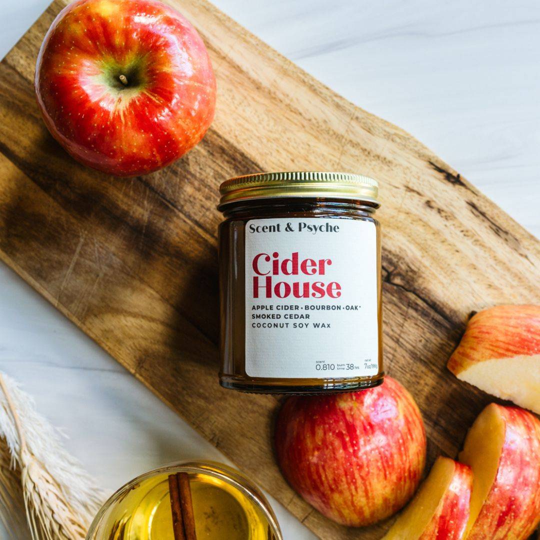 Cider House scented candle in a 7oz amber jar with a coconut soy wax blend, featuring apple cider, bourbon, oak, and smoked cedar aromas. Perfect for fall home decor.