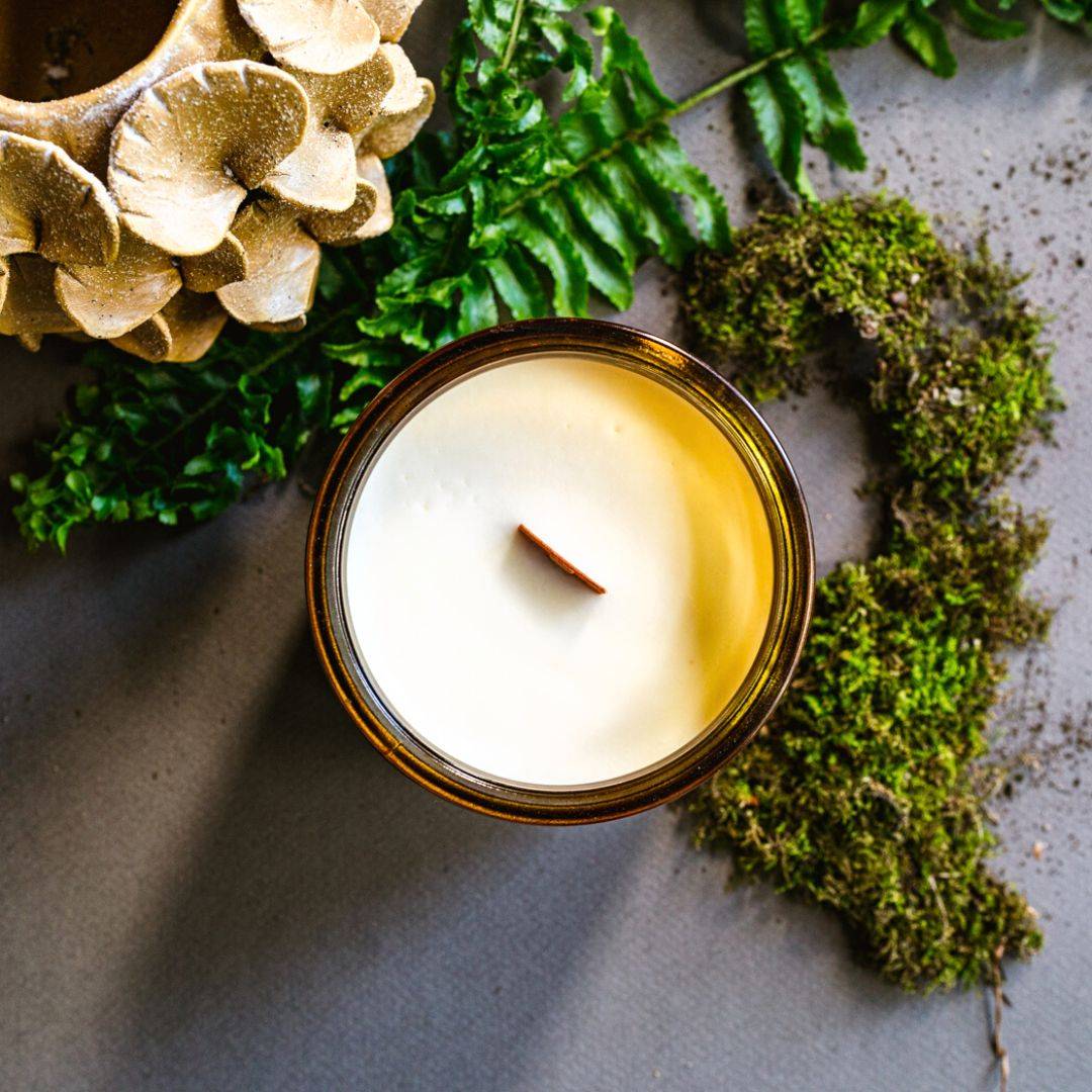 Top view of the Forest Scented Candle in a 12oz amber jar, showcasing a coconut soy wax blend with a wooden wick. Ideal for a cozy and refreshing atmosphere.