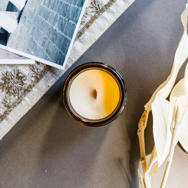 Top view of the Heirloom Scented Candle in a 4oz amber jar, showcasing a wooden wick and creamy coconut soy wax for a warm, aromatic experience.