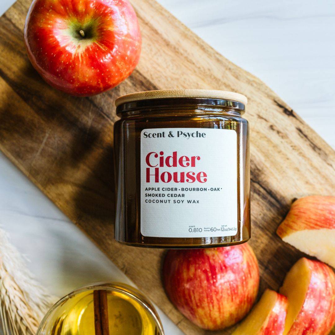 Cider House 12oz amber jar scented candle with apple cider, bourbon, oak, and smoked cedar fragrance. Perfect for fall home decor and ambiance.