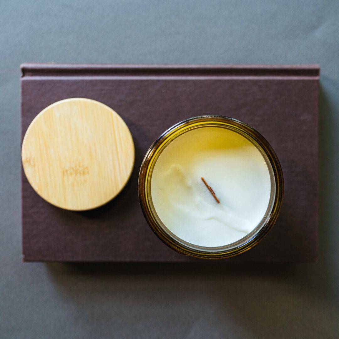 Top view of Escape by Fiction Scented Candle in a 15oz amber jar, showcasing its smooth coconut soy wax and wooden wick for a clean burn.