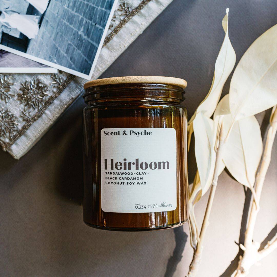 Heirloom Scented Candle in a 15oz amber jar with a minimalist label, featuring sandalwood, clay, and black cardamom fragrance. Aesthetic home decor piece.