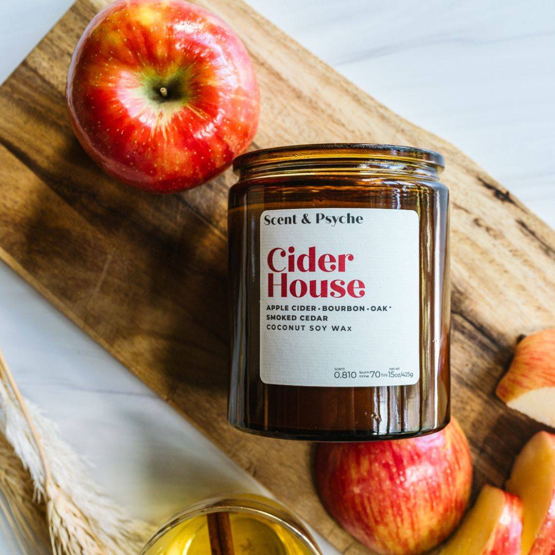 Cider House 15oz amber jar scented candle with apple cider, bourbon oak, and smoked cedar fragrance. Perfect for fall home decor and cozy ambiance.