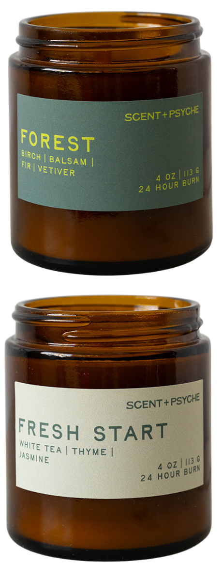 Two amber glass jar candles on a white background, one labeled Forest and one labeled Fresh Start, from Scent + Psycho.