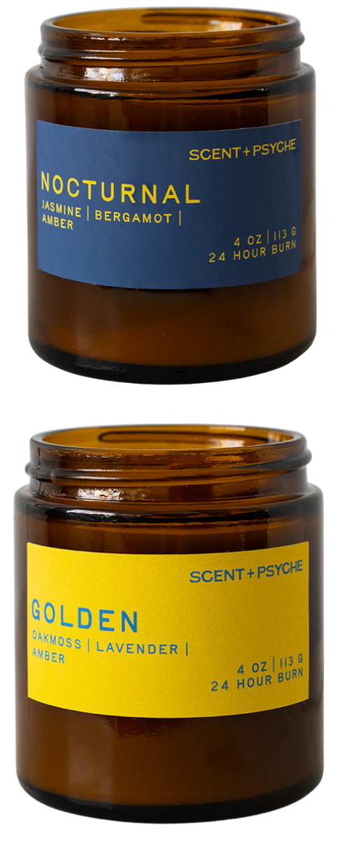 Two amber glass jar candles from Scent + Psyche on a white background, one labeled 'Nocturnal Jasmine & Bergamot' with a blue label and the other labeled 'Golden Lavender' with a yellow label.