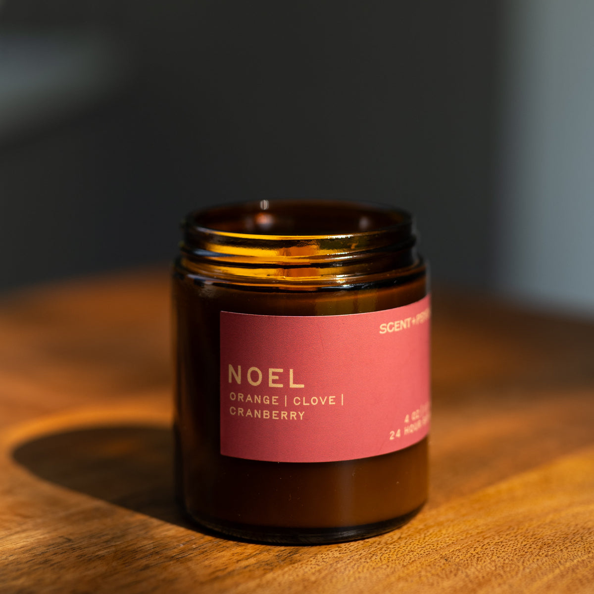 Noel candle on a wooden surface with a dark gray background