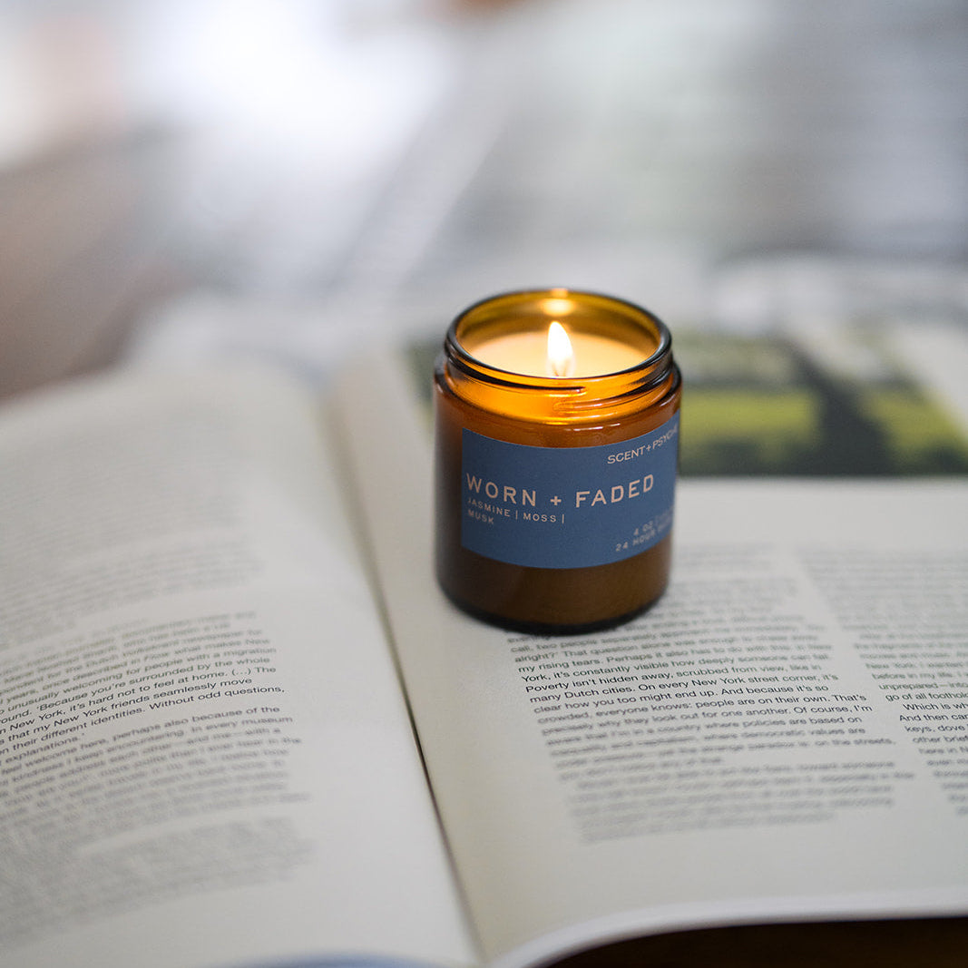 Worn and Faded wood wick candle beside an open book, cozy everyday scented candle — Scent & Psyche