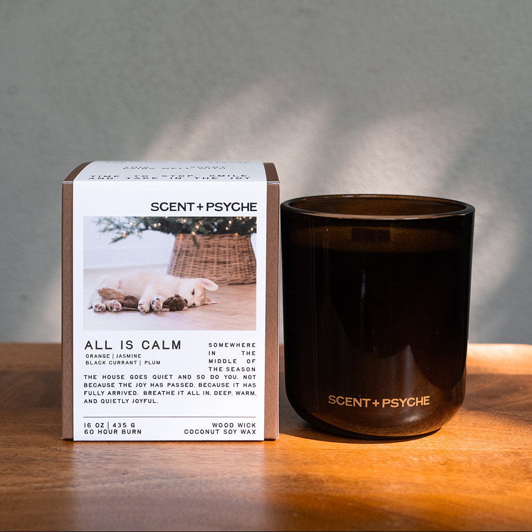 All is Calm Statement size candle next to its Scent + Psyche gift box in window light